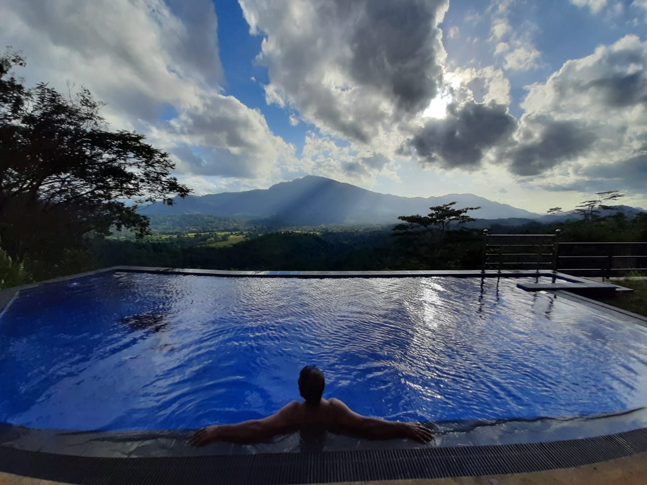 Guest relaxing in the Terrace Cinnamon View infinity pool at sunset
