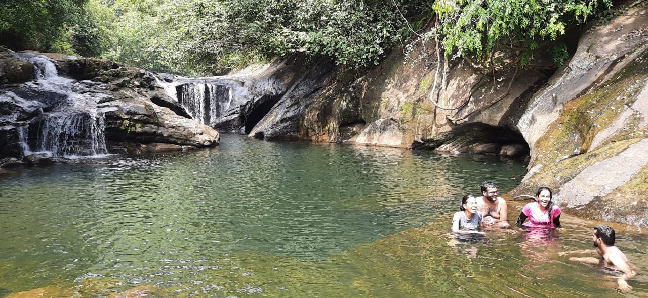 Guests swimming in a waterfall pool on a Terrace Cinnamon View excursion