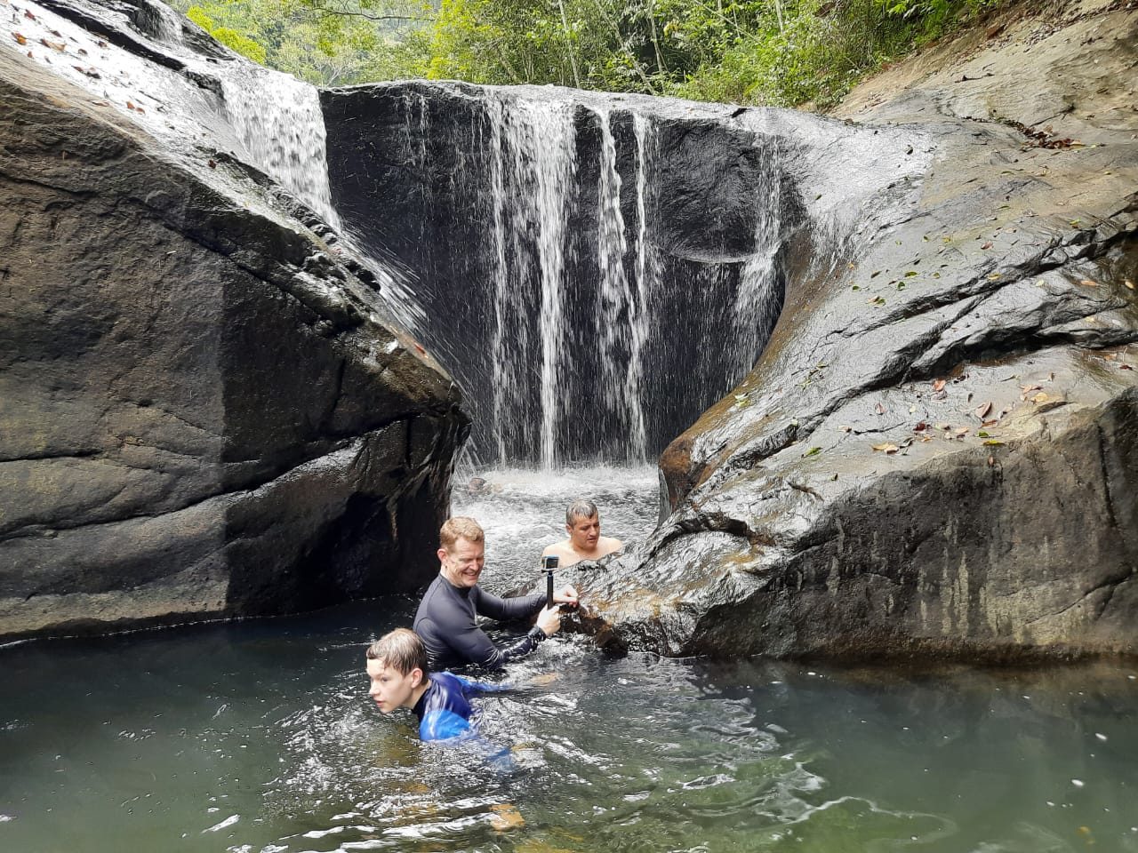 Guests bathing in a waterfall cave pool near Terrace Cinnamon View