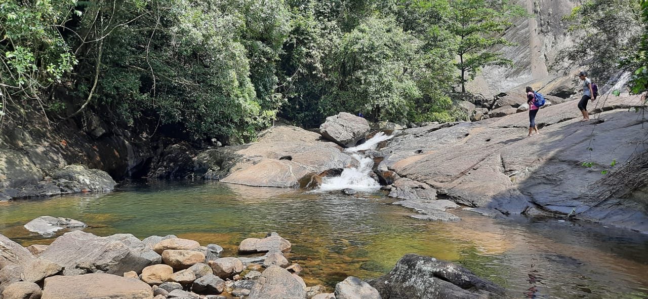 Hikers at a river pool along the nature trail near the estate